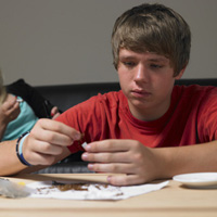Adolescent en train de préparer un joint de cannabis