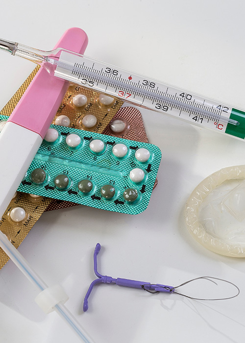Médecin tenant une plaquette de pilules contraceptives dans une main et un diu dans l'autre