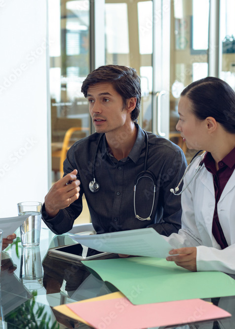 Médecin souriant à une patiente âgée allongée dans un lit en EHPAD