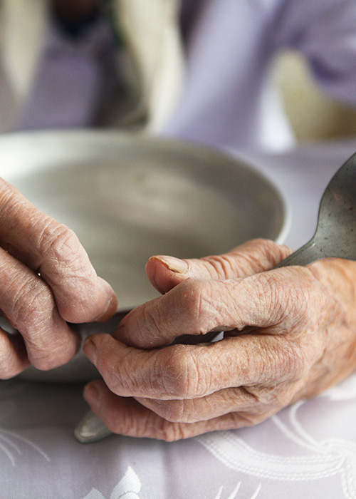 Personne âgée mangeant une soupe dans un réfectoire