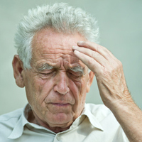 Douleur de la personne âgée : homme âgé souffrant qui se tient la tête