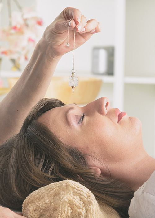 Médecin tenant le poignet de son patient couché lors d'une séance d'hypnose