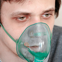 Jeune homme avec une insuffisance respiratoire chronique s'aidant d'un masque à oxygène