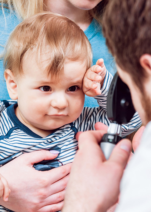 Médecin réalisant un test auditif sur un enfant